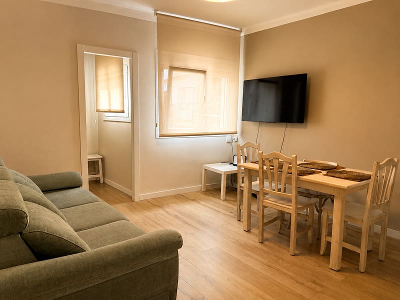 Apartamento Acogedor by Cozycatalonia | Salón comedor Salón comedor con sofá, mesa y televisión