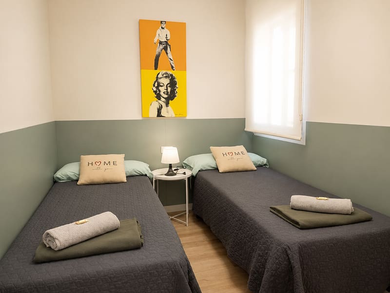 Apartamento Acogedor by Cozycatalonia | Dormitorio con dos camas individuales Dormitorio con dos camas individuales y mesita de noche
