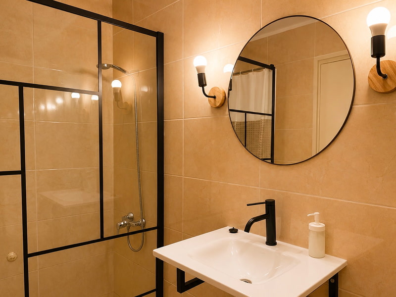 Apartamento by Cozycatalonia | Baño con ducha Baño con ducha, lavabo y espejo redondo