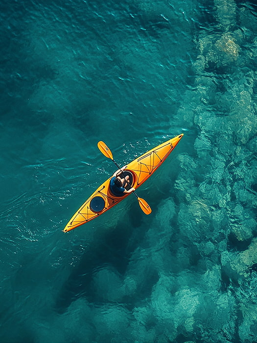 Actividades acuáticas en la Costa Brava Persona practicando kayak sobre aguas cristalinas