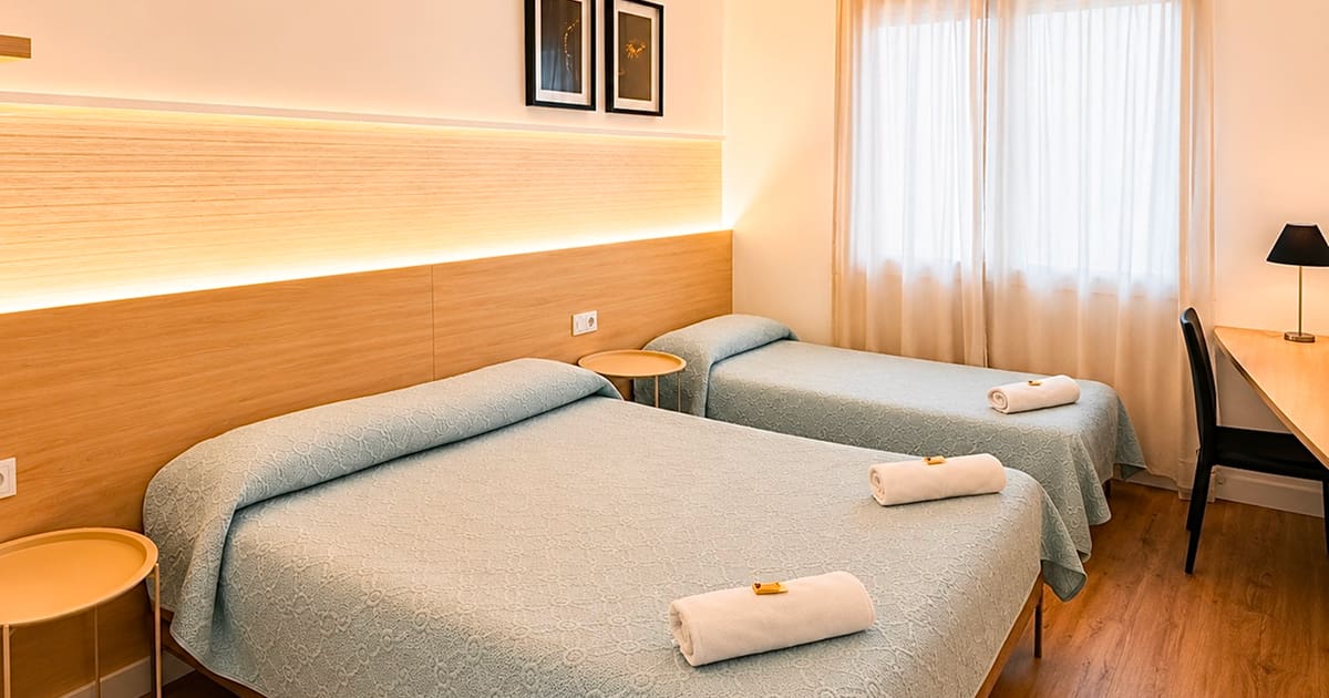 Habitación triple con camas individuales con iluminación cálida