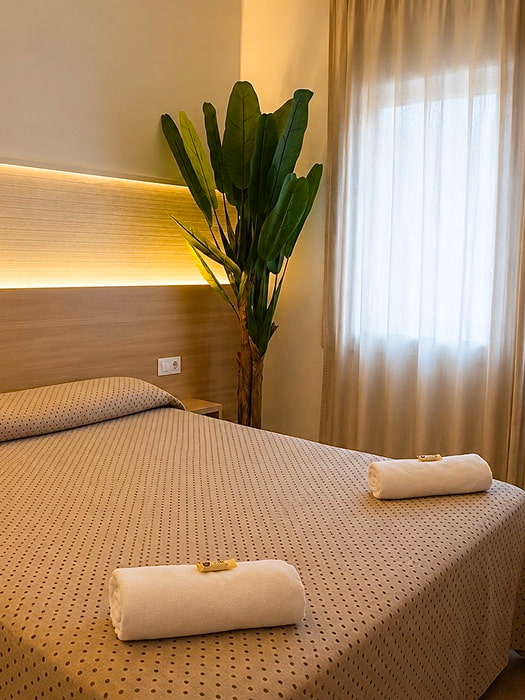 Dormitorio doble con cama grande e iluminación cálida