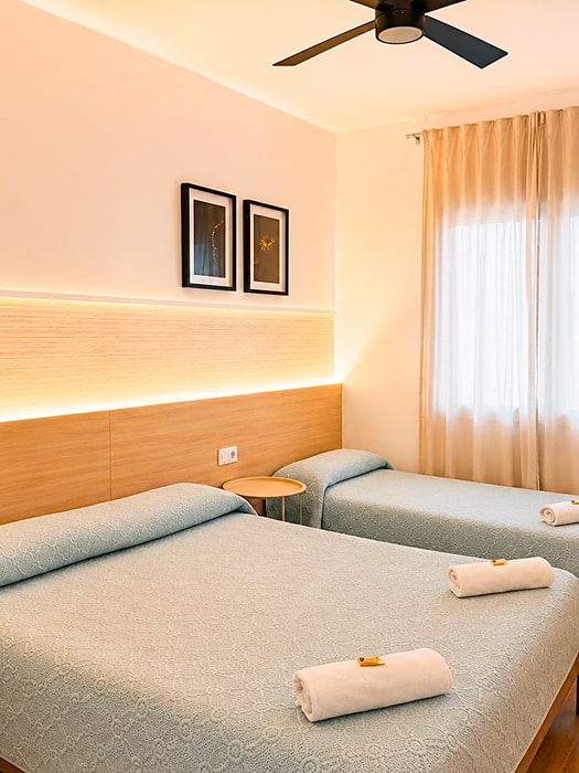 Habitación triple espaciosa con varias camas