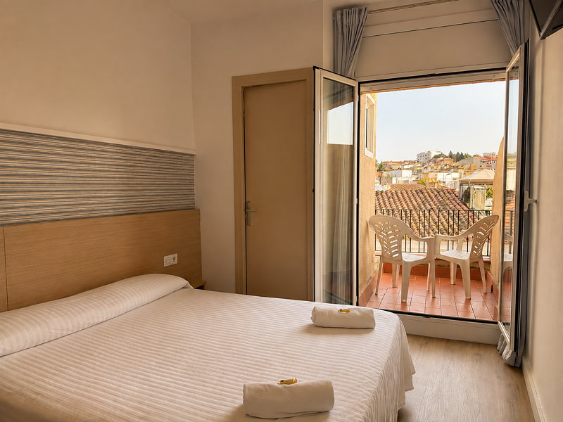 Dormitorio luminoso con cama doble y acceso al exterior