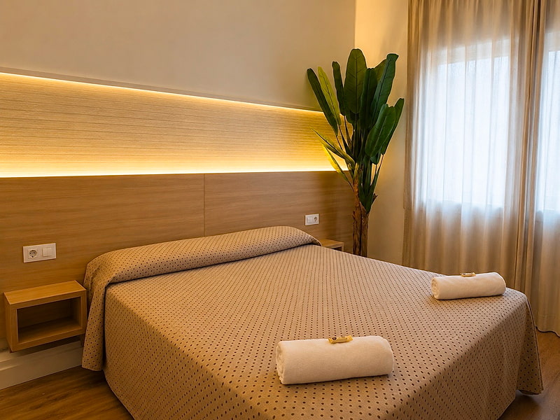 Dormitorio moderno con escritorio y detalles cálidos en madera