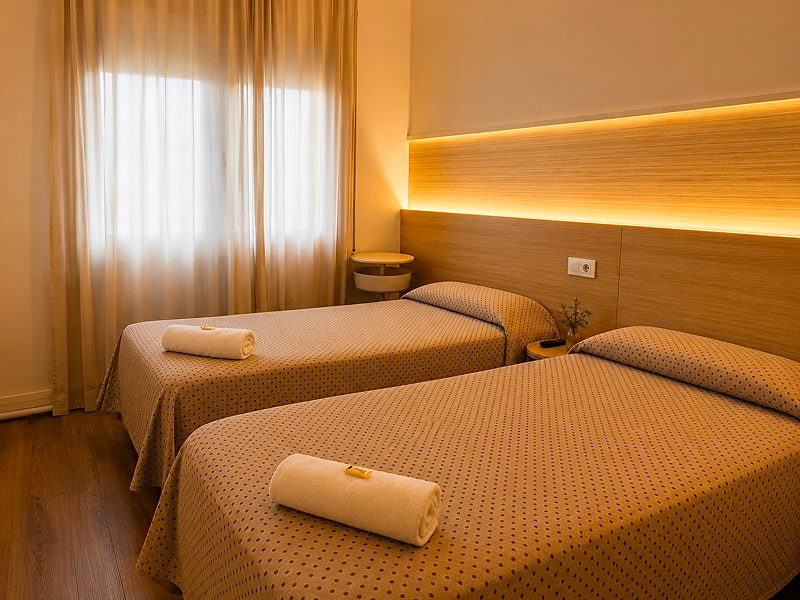 Dormitorio con dos camas individuales y luz natural