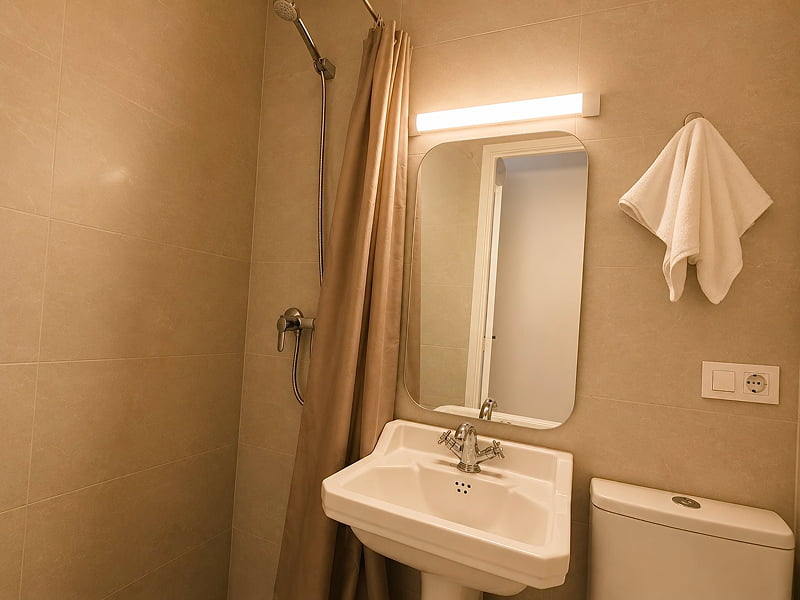 Baño con ducha y acabados neutros