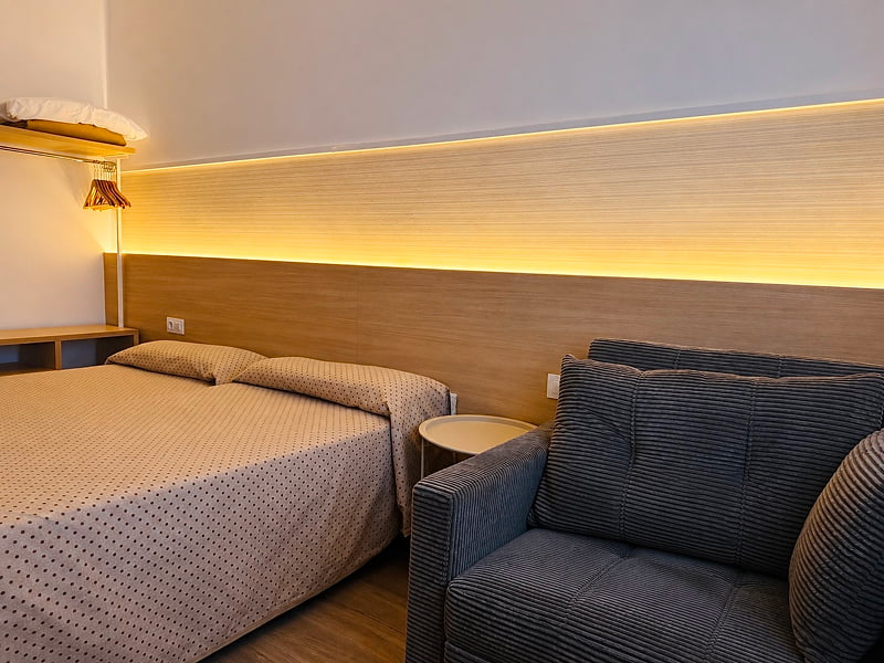 Sofá acolchado junto a la zona de cama en una habitación