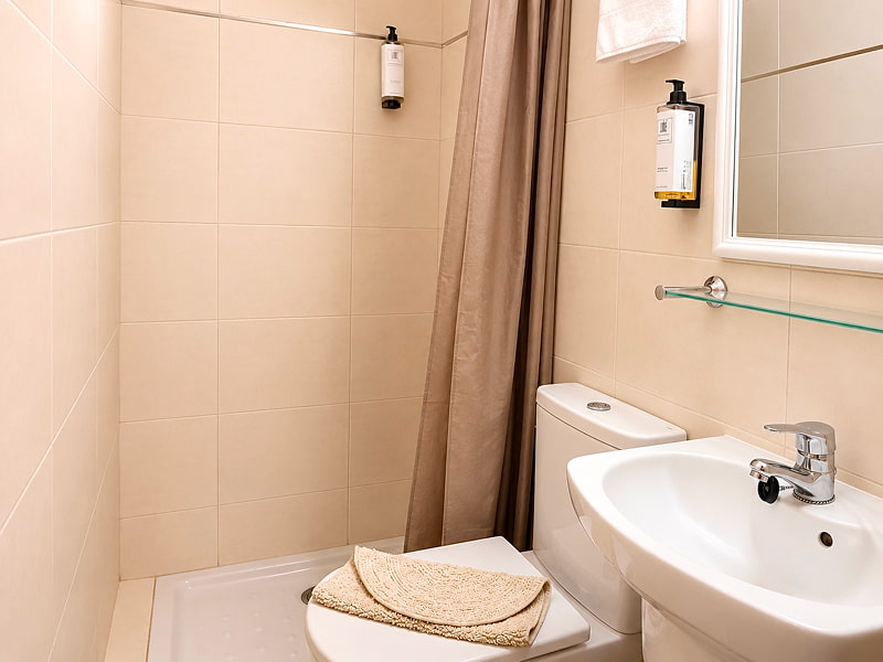 Baño moderno con ducha, lavabo y acabados en tonos claros